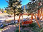 The outdoor swing is located with views of the mountains under the pines